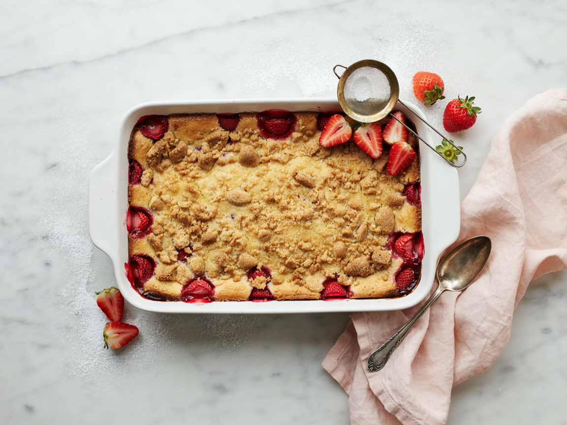 Overhead view of a strawberry cheesecake dump cake dusted with powdered sugar